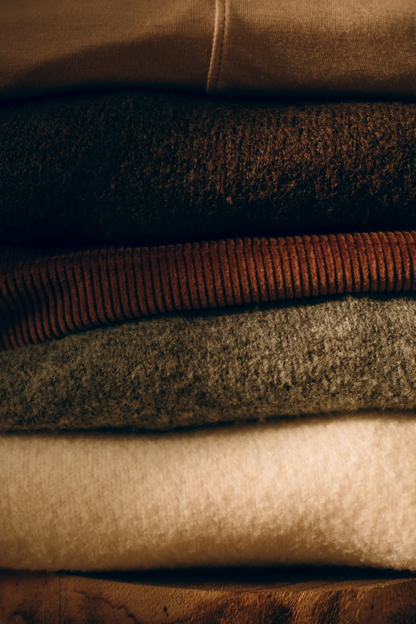 A stack of folded knitwear in neutral colours