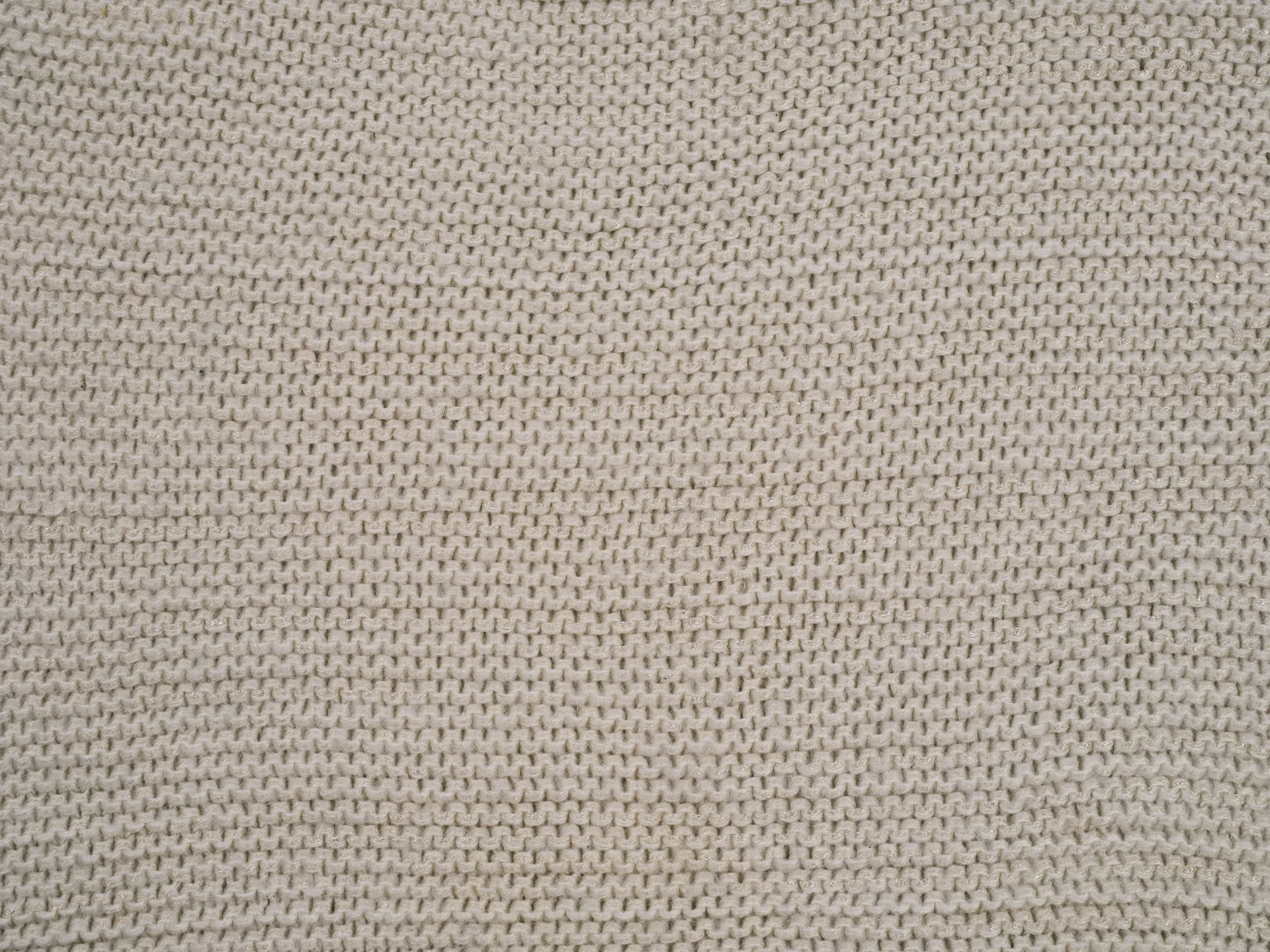 Extreme close-up of a cream knitted stitch