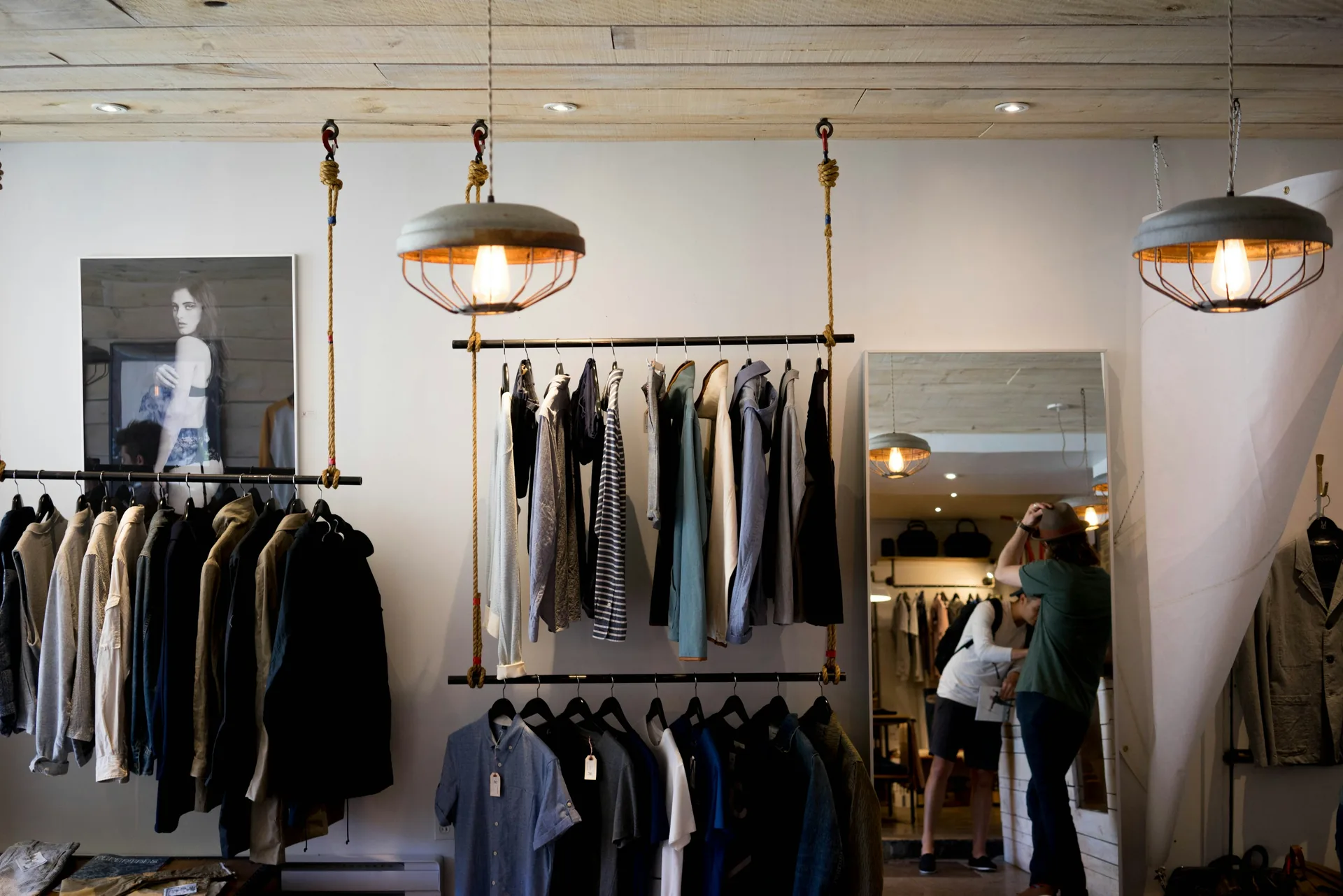 A clothing boutique interior with garments on hanging rails